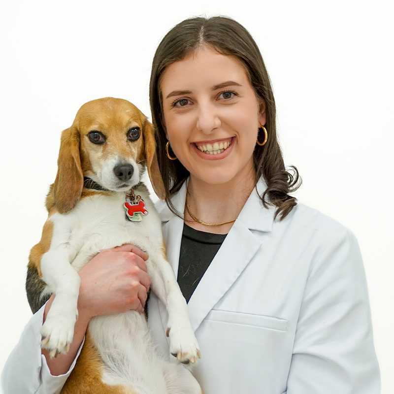 Dr Samantha Sula posing for a picture with a dog on a white background