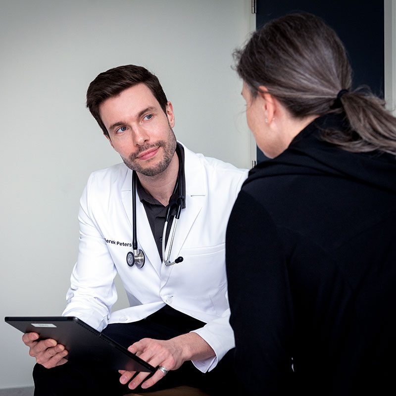 Veterinarian Near Burlington veterinarian holding a clipboard looking up at a patient